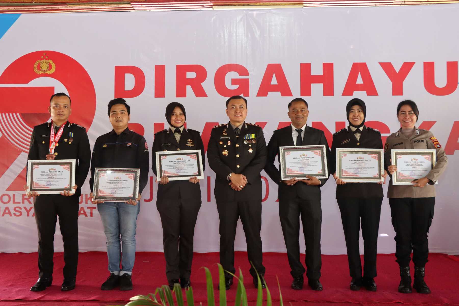 Lombok Barat, NTB – Kepolisian Republik Indonesia (Polri) merayakan ulang tahunnya yang ke-79 pada 1 Juli 2025. Di Lombok Barat, peringatan Hari Bhayangkara kali ini selain dengan menggelar upacara, juga ditandai dengan acara tasyakuran yang penuh makna. Menegaskan kembali komitmen Polri untuk terus meningkatkan kualitas pelayanan kepada masyarakat. Pada Selasa (1/7/2025), suasana di bencingah kantor Bupati Lombok Barat tampak semarak dengan kehadiran para pejabat dan tokoh masyarakat. Acara Tasyakuran Hari Bhayangkara ke-79 ini digelar di Jalan Soekarno-Hatta, Kelurahan Dasan Geres, Kecamatan Gerung, Kabupaten Lombok Barat, menjadi momentum penting. Untuk mempererat sinergitas antara Polri, TNI, pemerintah daerah, dan seluruh elemen masyarakat. Meningkatkan Pelayanan dan Memperkuat Sinergi Dalam sambutannya yang penuh semangat, Kapolres Lombok Barat, AKBP Yasmara Harahap, S.I.K., menyampaikan bahwa Hari Bhayangkara ke-79 mengusung tema ‘Polri untuk Masyarakat’. Menurutnya, tema ini bukan sekadar slogan, melainkan sebuah amanah untuk terus berbenah. "Dalam rangka Hari Bhayangkara ke-79 tahun 2025 dengan tema Polri Untuk Masyarakat, tentunya kita harus meningkatkan kualitas diri sebagai insan Bhayangkara. Untuk melaksanakan pelayanan maksimal kepada masyarakat," ujar AKBP Yasmara. Ia menekankan pentingnya introspeksi diri dan peningkatan kinerja untuk memberikan pelayanan terbaik. "Polri tegak berdiri dan berkomitmen untuk menjadi lebih modern dan terpercaya," tambahnya. Menurut Kapolres, semua upaya ini bertujuan utama untuk menjaga stabilitas keamanan dan ketertiban masyarakat (kamtibmas) di Provinsi NTB agar tetap kondusif. Ia juga menjelaskan bahwa rangkaian kegiatan dalam rangka Hari Bhayangkara di Polres Lombok Barat sudah dimulai sejak awal Juni. Dengan berbagai kegiatan yang menyentuh langsung masyarakat. AKBP Yasmara Harahap juga menyampaikan rasa terima kasihnya kepada semua pihak yang telah mendukung tugas-tugas Polri. "Terima kasih kepada Bapak Bupati yang telah mendukung tugas-tugas kamtibmas. Tidak mungkin kami berjalan sendiri tanpa dukungan dari Pemda dan seluruh elemen masyarakat," tegasnya. Kolaborasi Pemerintah dan Polri untuk Pelayanan Optimal Senada dengan Kapolres, Bupati Lombok Barat, H. Lalu Ahmad Zaini, S. Si., M.T., juga memberikan apresiasi setinggi-tingginya kepada jajaran kepolisian. Dalam pernyataannya, Bupati mengucapkan selamat Hari Bhayangkara dan menekankan pentingnya sinergi antara pemerintah daerah dan Polri. "Atas nama Pemerintah Kabupaten Lombok Barat, kami menyampaikan dirgahayu Kepolisian," kata Bupati Lalu Ahmad Zaini. "Sinergitas dan kolaborasi akan terus kita tingkatkan agar pelayanan kepada masyarakat akan terus dapat dioptimalkan,” imbuhnya. Pernyataan ini menunjukkan komitmen kuat dari pemerintah daerah untuk terus bekerja sama dengan Polri demi kesejahteraan dan keamanan masyarakat Lombok Barat. Momen Kebersamaan dan Apresiasi Setelah sambutan, acara dilanjutkan dengan momen simbolis pemotongan kue dan tumpeng. Kapolres Lombok Barat bersama Ibu Ketua Bhayangkari, Bupati Lombok Barat, perwakilan Dandim 1606, Wakil Bupati, Sekda, dan Ketua DPRD secara bersama-sama melakukan pemotongan tumpeng, melambangkan kebersamaan dan rasa syukur. Kemeriahan acara juga terasa saat pembacaan dan penyerahan hadiah bagi para pemenang lomba-lomba yang diselenggarakan dalam rangka memeriahkan Hari Bhayangkara ke-79. Berbagai lomba tersebut tidak hanya menjadi ajang silaturahmi, tetapi juga menunjukkan partisipasi aktif masyarakat dalam perayaan hari jadi korps Bhayangkara. Peringatan Hari Bhayangkara ke-79 ini menjadi momentum refleksi bagi seluruh jajaran Polres Lombok Barat untuk terus berbenah dan meningkatkan kualitas diri. Turut hadir pula dalam acara ini, Ketua Cabang Bhayangkari Lombok Barat, Ny. Citra Yasmara, bersama jajaran pengurus. Serta perwakilan dari Kodim 1606 Mataram, Letkol Inf. Abdul Haris S.H. M.H. Selain itu, hadir pula Wakil Bupati Lombok Barat, Hj. Nurul Adha, S.THI, Sekda Kabupaten Lombok Barat, H. Ilham S.Pd M.Pd., Ketua DPRD Kabupaten Lombok Barat, Lalu Ivan Indaryadi, serta perwakilan dari Pengadilan Negeri Mataram dan Kejaksaan Negeri Mataram. Kehadiran para pimpinan OPD, tokoh agama, tokoh masyarakat, dan tokoh adat menunjukkan soliditas dukungan terhadap tugas-tugas kepolisian.